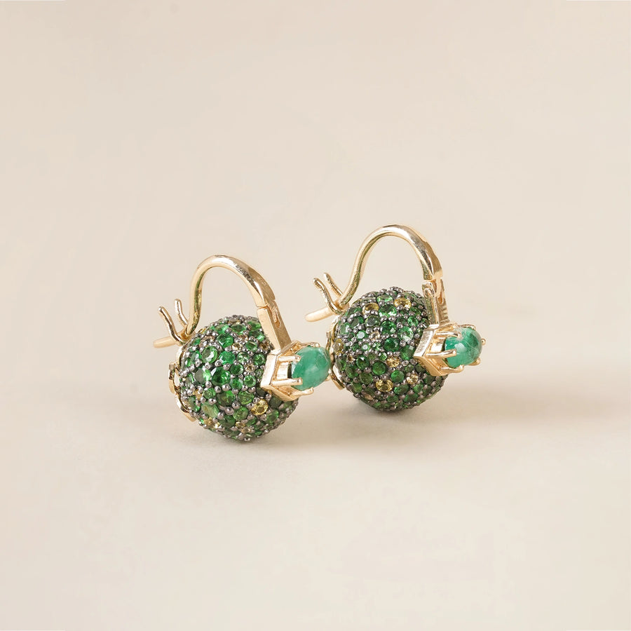 Forest-inspired earrings with pavé tsavorite, yellow sapphire, and emerald, featuring a central emerald set in gold.