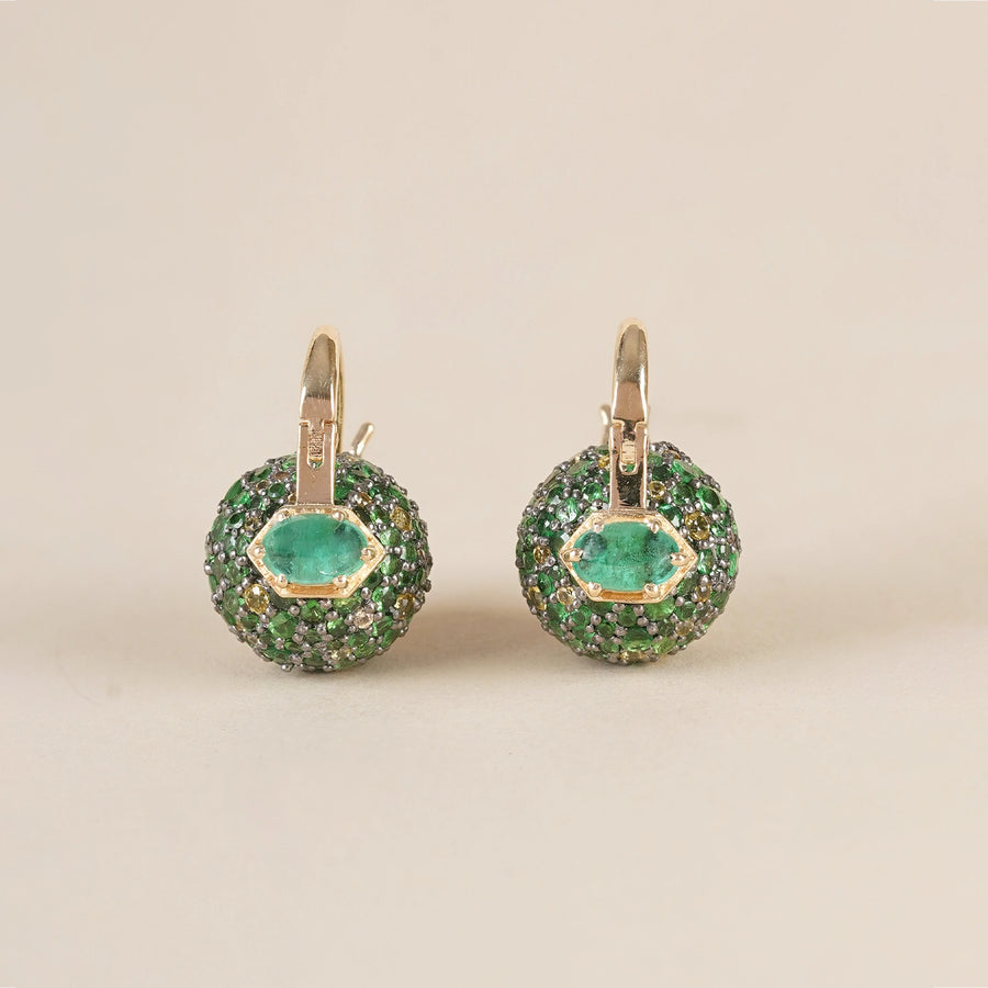 Forest-inspired earrings with pavé tsavorite, yellow sapphire, and emerald, featuring a central emerald set in gold.