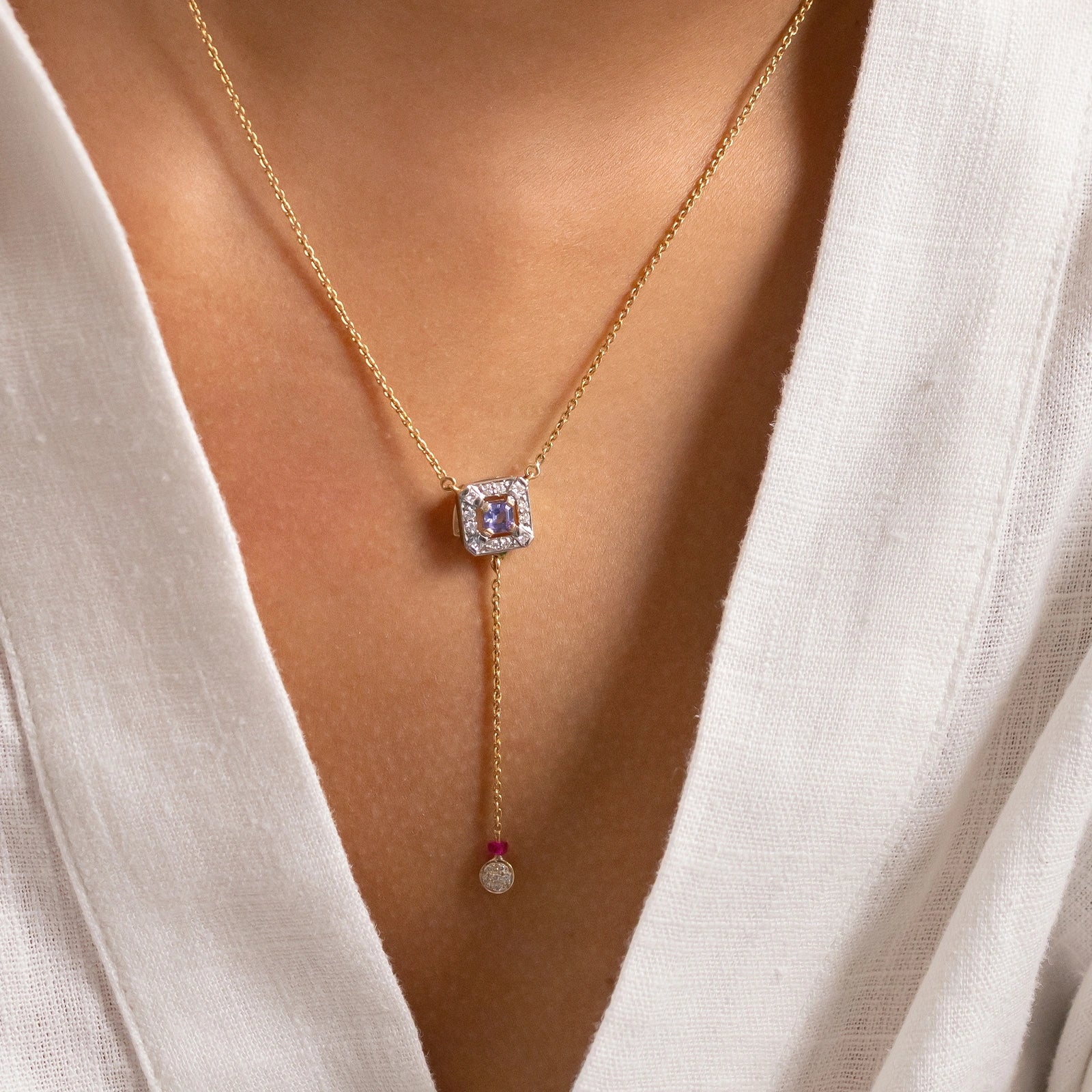 Nizam Tanzanite Pendant Necklace handcrafted in gold featuring a central tanzanite, brilliant and princess cut diamonds, green enamel detailing, and delicate dangling accents inspired by Indian artistry.